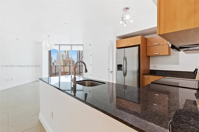a kitchen with stainless steel appliances granite countertop a sink and a refrigerator