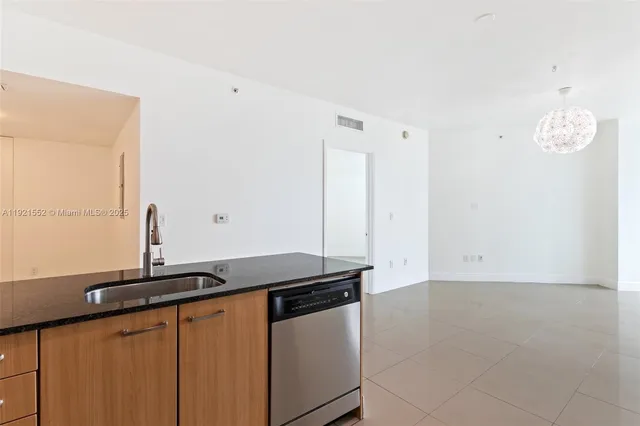a kitchen with granite countertop a sink and a stove