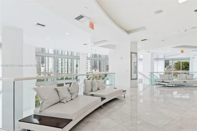 a living room with stainless steel appliances kitchen island a table and chairs
