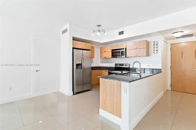 a kitchen with stainless steel appliances granite countertop a refrigerator stove and a sink