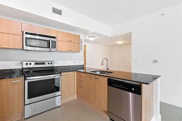 a kitchen with stainless steel appliances granite countertop a stove microwave and sink