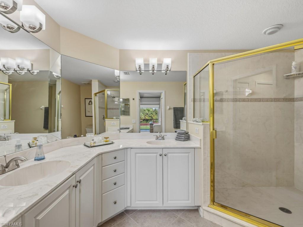 6095 Pinnacle Lane, Unit 1304 Naples, FL 34110 - Photo 13 of 47 a spacious bathroom with a double vanity sink mirror and shower