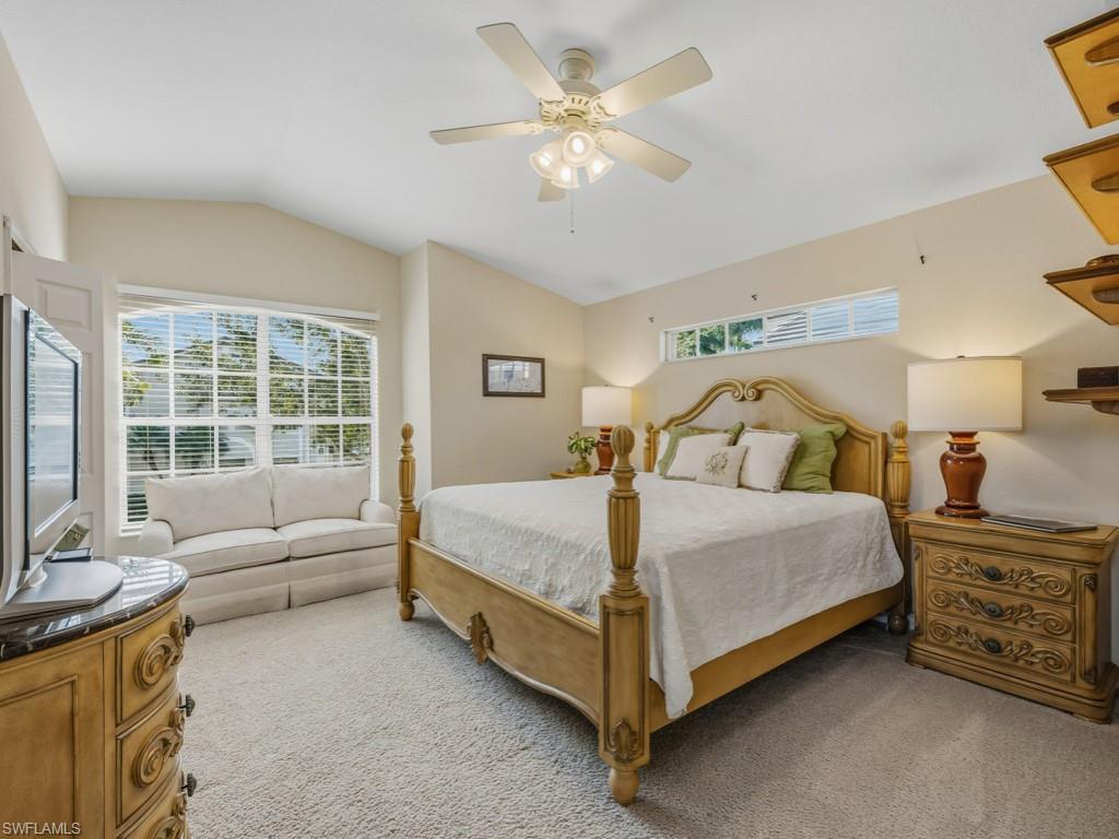 6095 Pinnacle Lane, Unit 1304 Naples, FL 34110 - Photo 15 of 47 a bedroom with a bed a couch and a flat tv screen on dresser