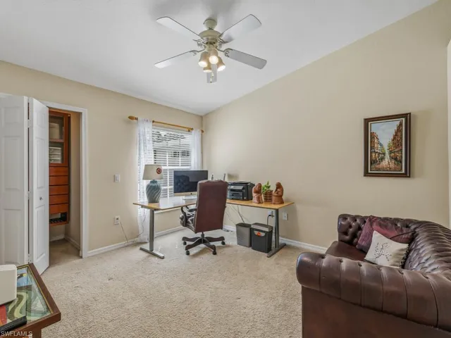 a bedroom with a bed a couch and a flat tv screen on dresser