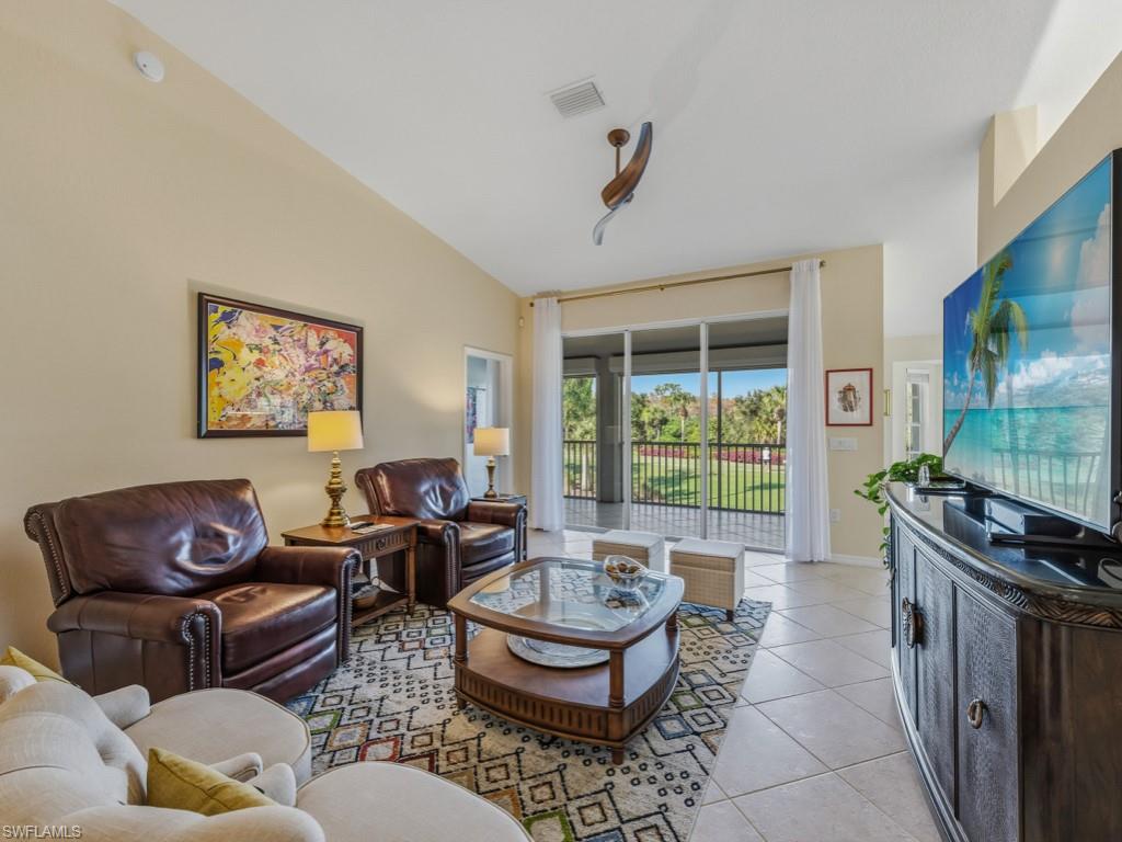 6095 Pinnacle Lane, Unit 1304 Naples, FL 34110 - Photo 5 of 47 a living room with furniture and a flat screen tv