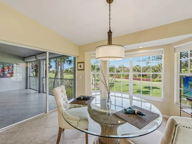 a dining room with furniture large windows and a chandelier