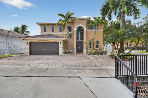 a front view of a house with yard and parking