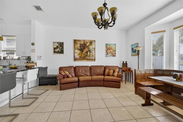 a living room with furniture a dining table and a window
