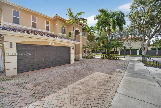 a view of a building with a yard and palm trees