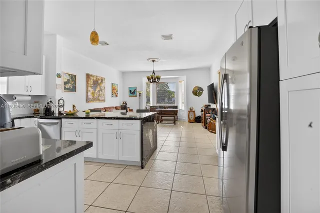 a kitchen with kitchen island granite countertop a refrigerator and a counter top space
