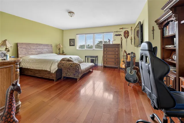 a spacious bedroom with a bed and a wooden floor