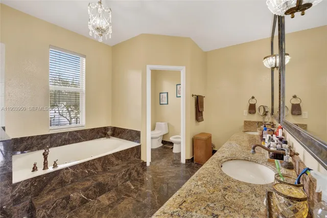 a spacious bedroom with a bed and a chandelier