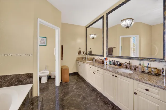 a spacious bathroom with a double vanity sink a mirror and a bathtub