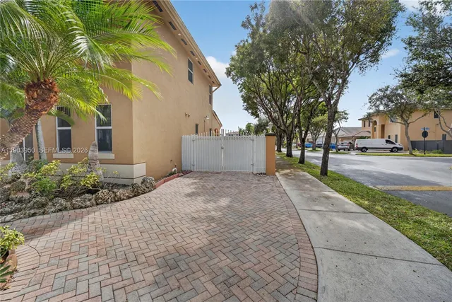 a front view of a house with a yard and potted plants