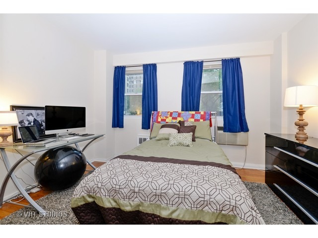2909 North Sheridan Road, Unit 112 Chicago, IL 60657 - Photo 8 of 12 a bedroom with a bed and a television