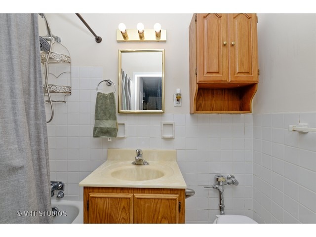 2909 North Sheridan Road, Unit 112 Chicago, IL 60657 - Photo 10 of 12 a bathroom with a sink a vanity and a mirror