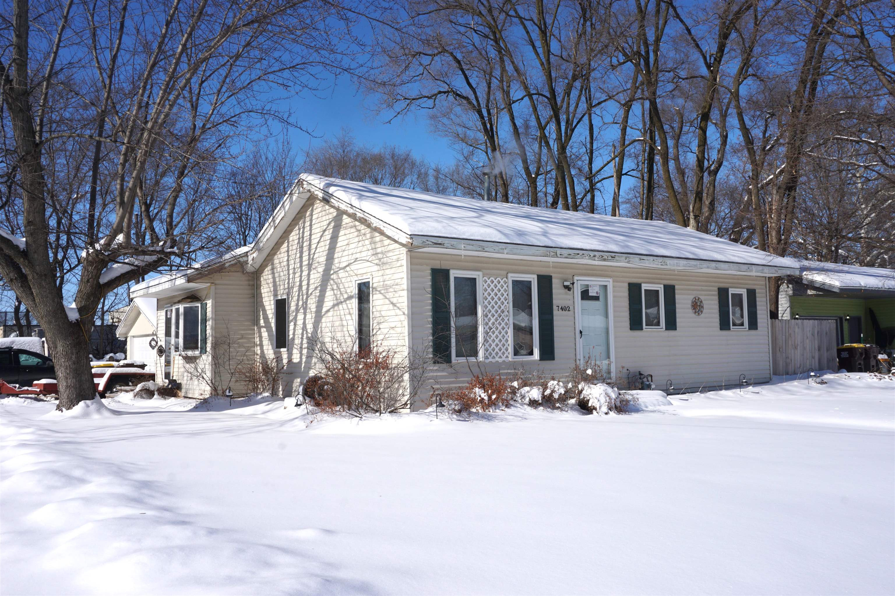 a front view of a house with a yard covered in snow