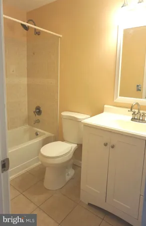 a bathroom with a toilet sink vanity and bathtub