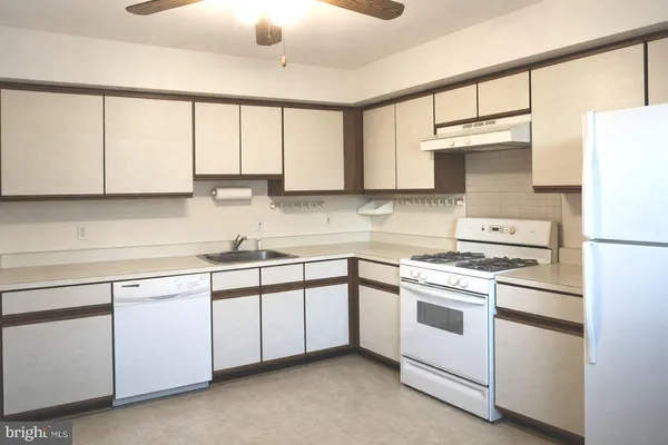 a kitchen with white cabinets and white appliances