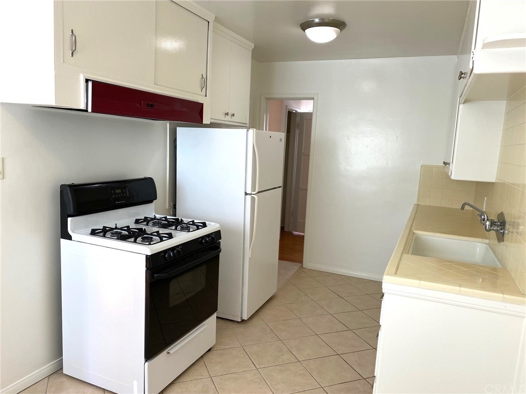 236 La Verne Avenue Long Beach, CA 90803 - Photo 5 of 8 a kitchen with a stove a refrigerator and a sink