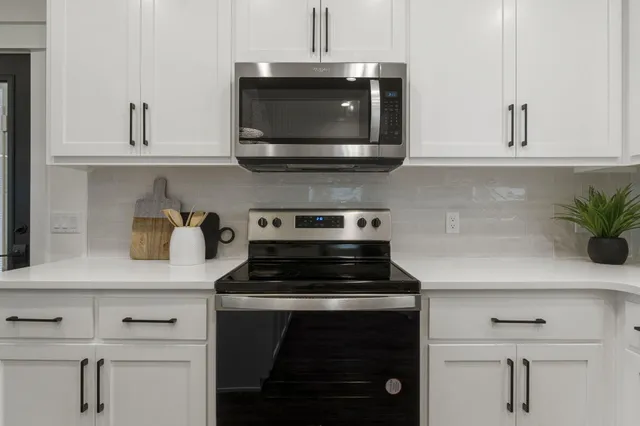 a kitchen with stainless steel appliances white cabinets and a stove