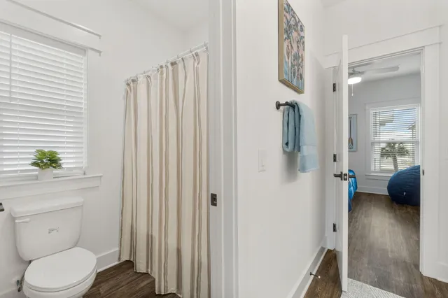 a en suite bathroom with a toilet a sink and shower curtain