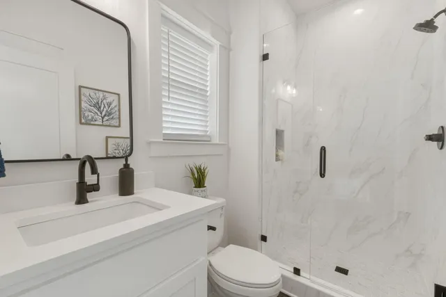a bathroom with a sink a toilet and shower