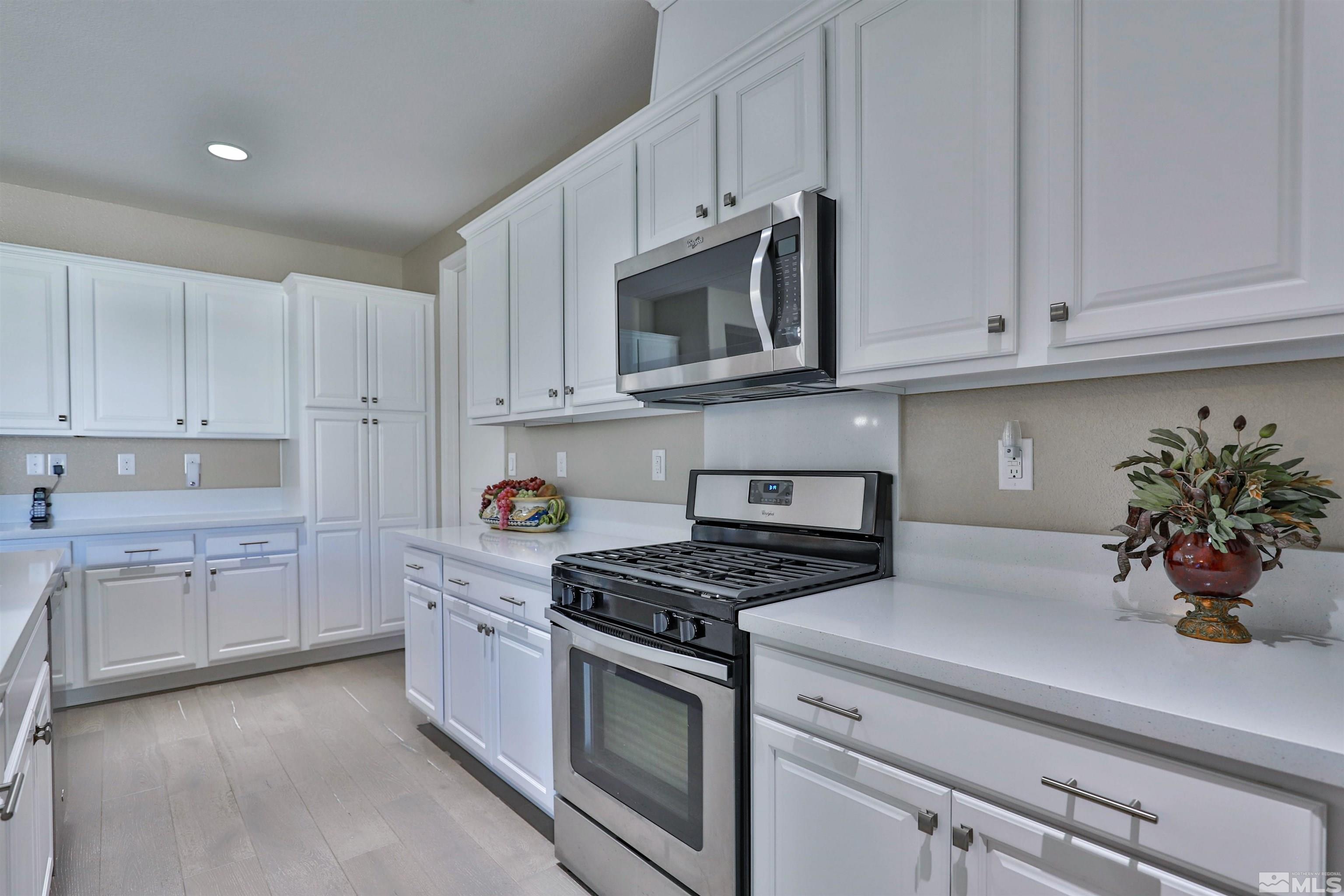 9860 Shadowless Trail Reno, NV 89521 - Photo 15 of 31 a kitchen with white cabinets and white appliances