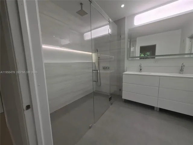 a bathroom with a sink a mirror and a shower
