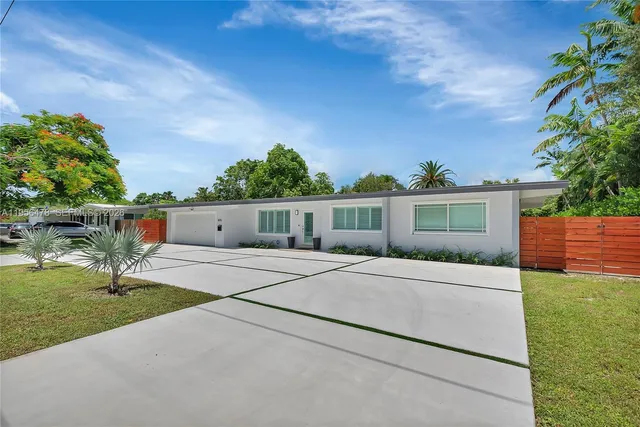 a front view of a house with a yard and trees