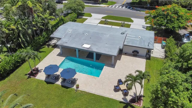 an aerial view of a house with swimming pool and garden