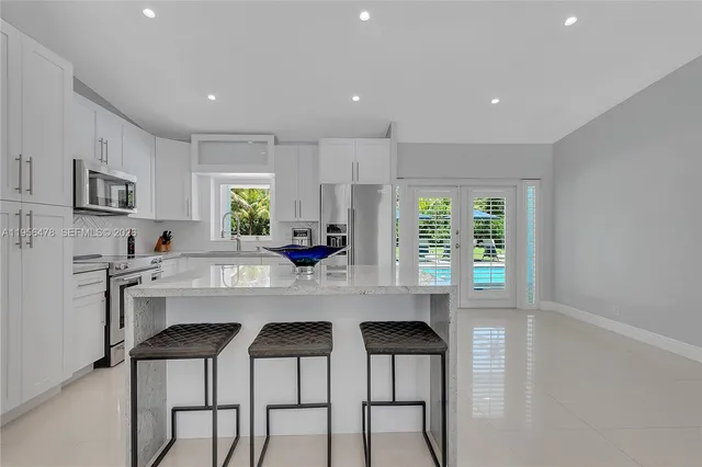 a kitchen with stainless steel appliances a table and chairs in it