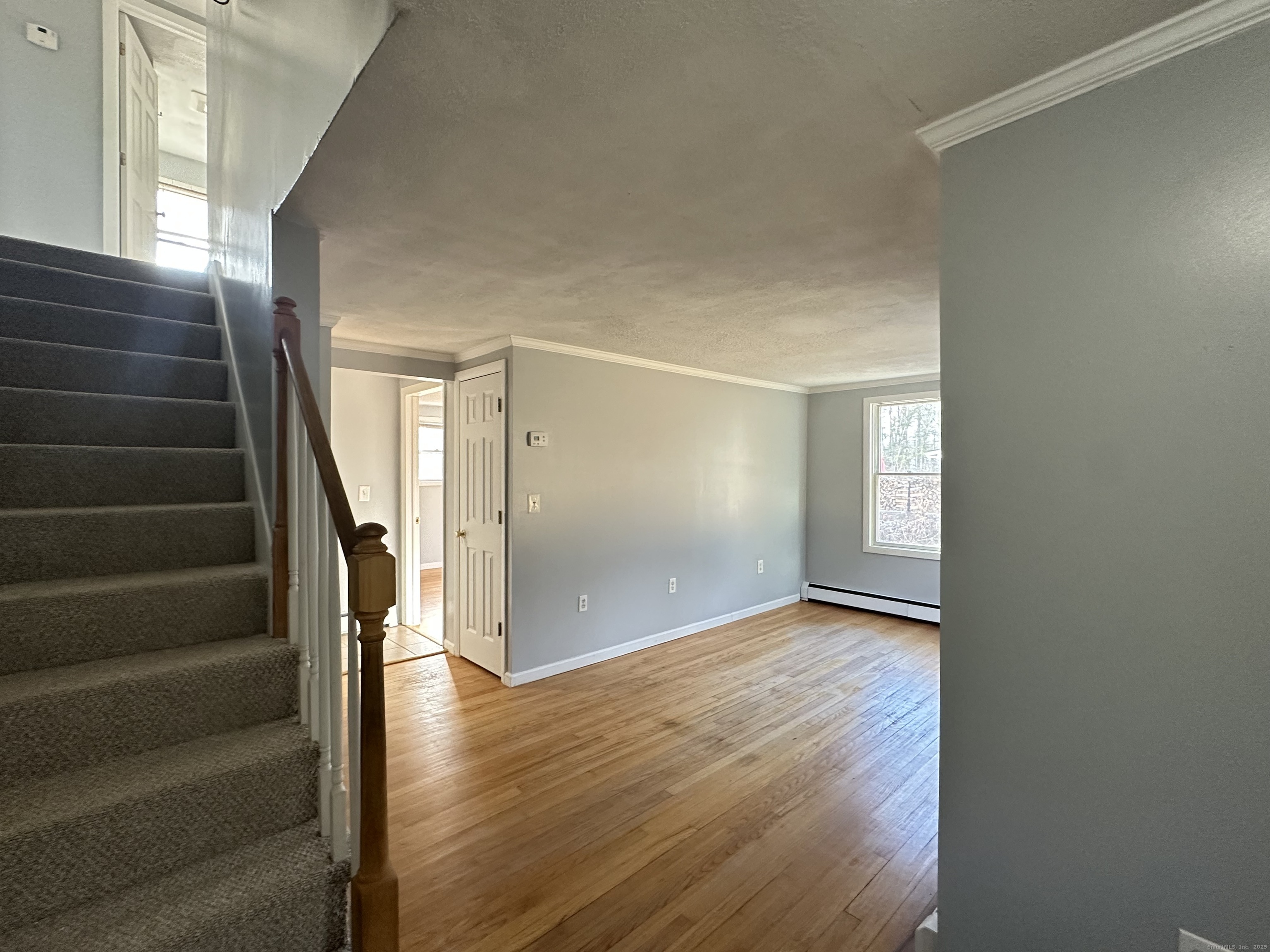 87 Scoville Road Avon, CT 06001 - Photo 12 of 16 a view of an empty room with stairs and wooden floor