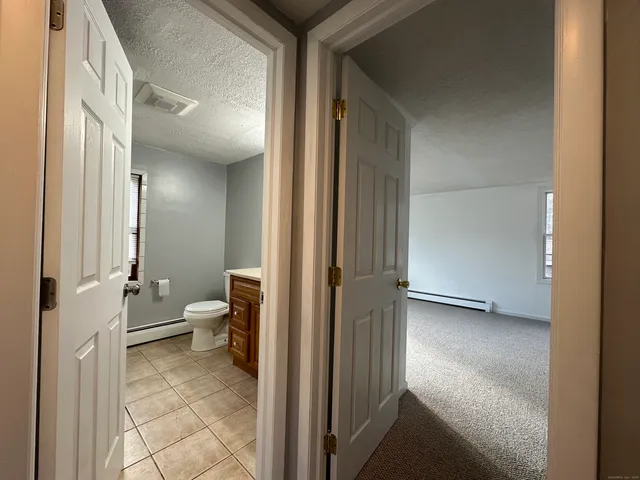 a view of a hallway with a livingroom and a bathroom