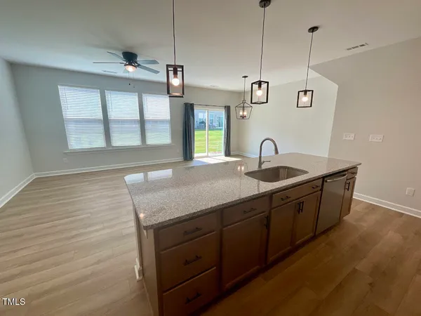 a view of a kitchen with a refrigerator a sink and wooden floor