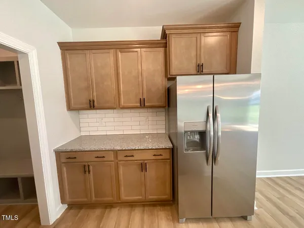 a kitchen with cabinets stainless steel appliances and wooden floor