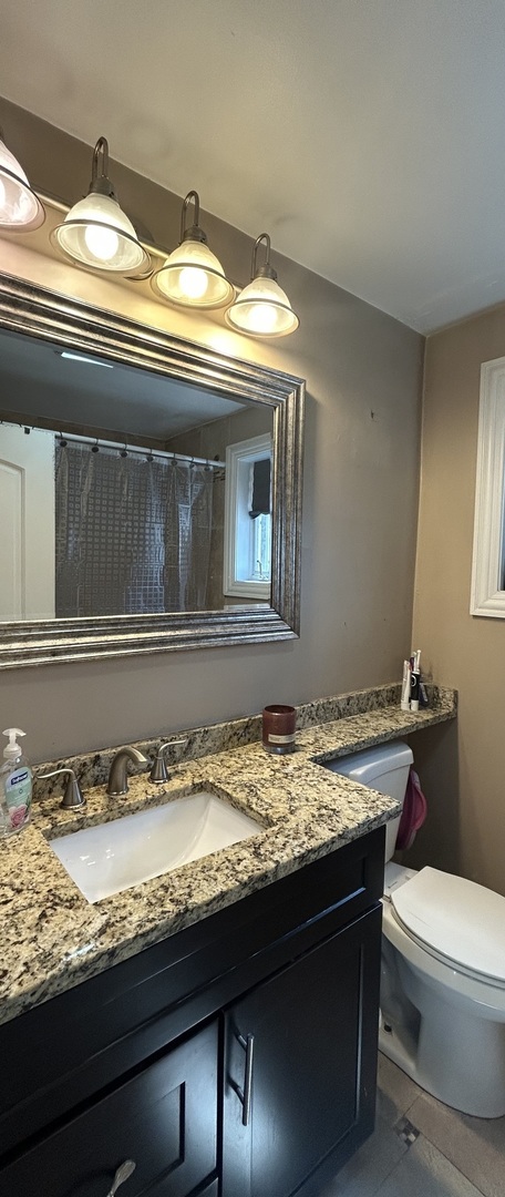 5810 South Austin Avenue Chicago, IL 60638 - Photo 7 of 11 a bathroom with a granite countertop sink and a toilet