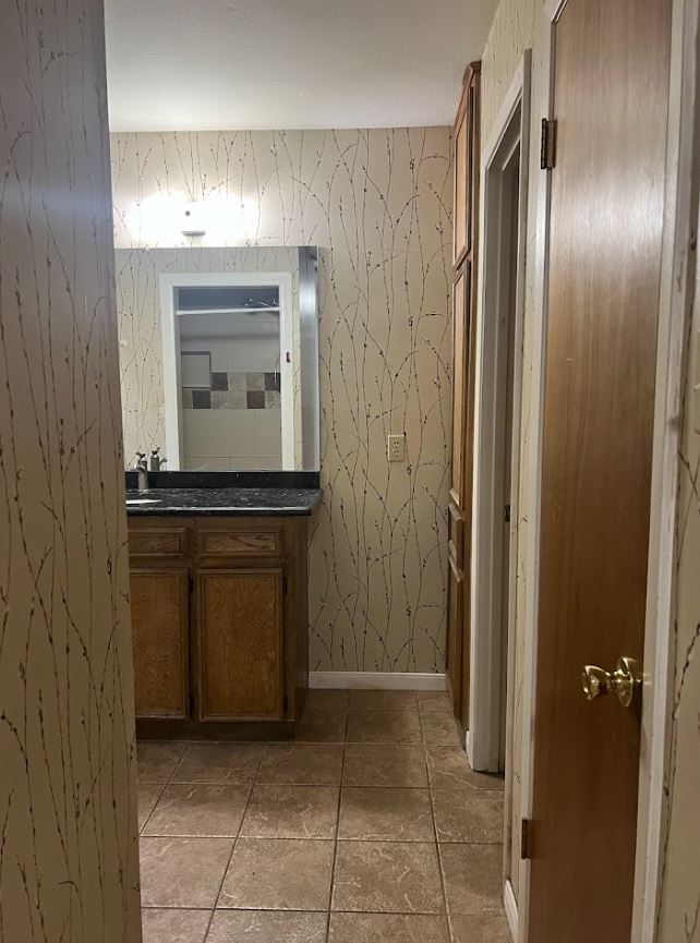 2813 1/2 Rio Grande Street, Unit 5 Austin, TX 78701 - Photo 15 of 21 a bathroom with a granite countertop sink and a mirror
