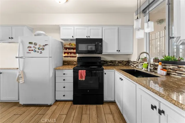 a kitchen with granite countertop a refrigerator and a stove