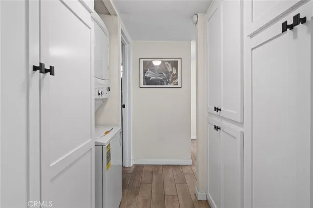 a view of a hallway with wooden floor and a bathroom