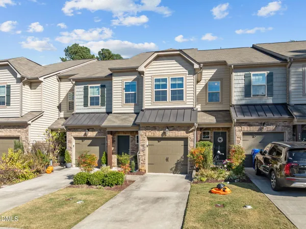 a front view of a house with cars parked