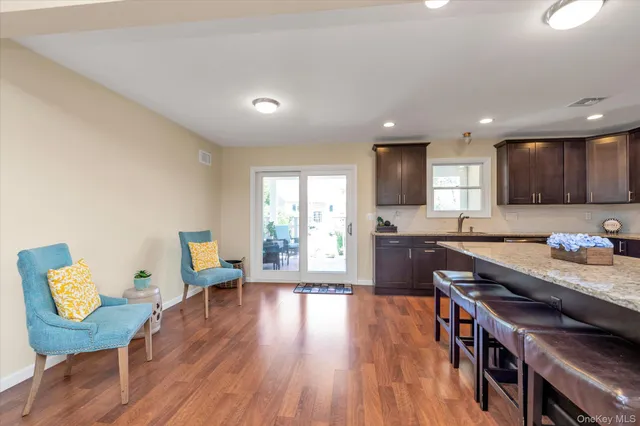 a kitchen with granite countertop wooden floors and wooden cabinets
