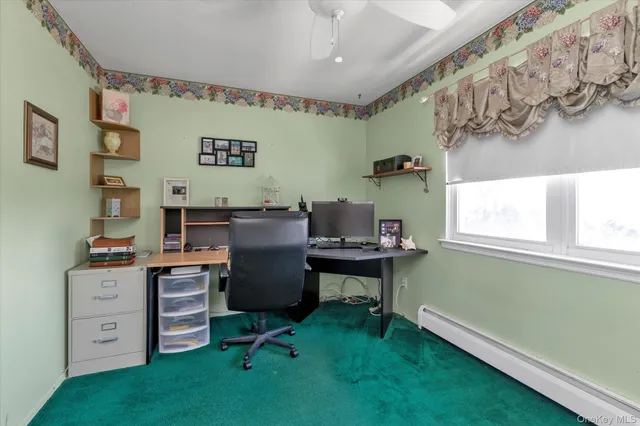 a view of a workspace with furniture and a window