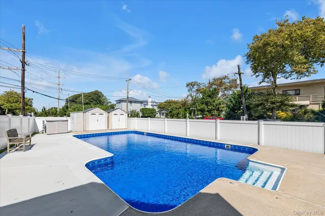 a view of a swimming pool with an outdoor seating and a palm tree