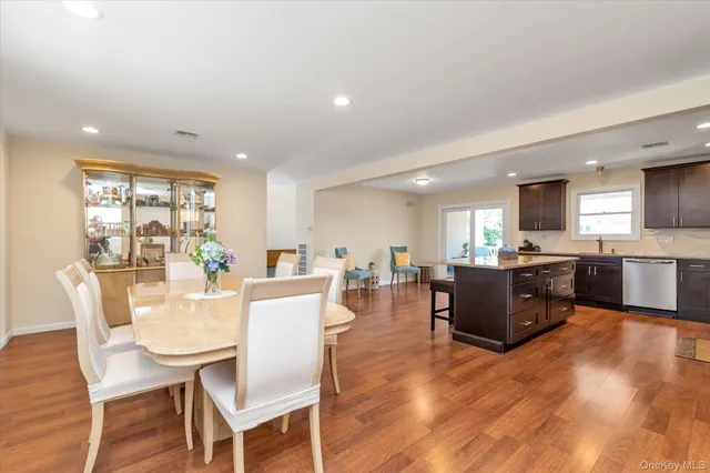 a view of a dining room with furniture a kitchen and chandelier