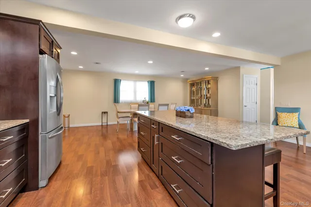 a kitchen with stainless steel appliances granite countertop a lot of counter space and wooden floors