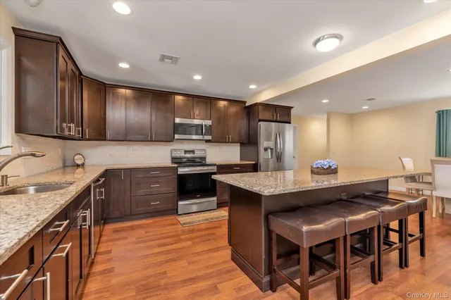 a kitchen with granite countertop a sink counter top space stainless steel appliances and cabinets