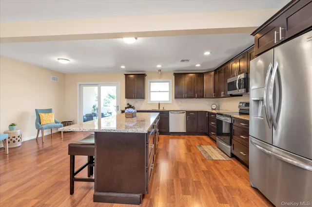 a large kitchen with a table chairs refrigerator and wooden floor