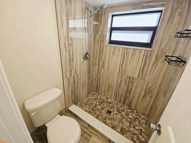 a bathroom with a toilet and a shower