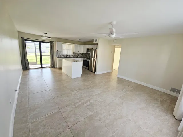 a view of a kitchen with a sink and dishwasher a refrigerator with white walls
